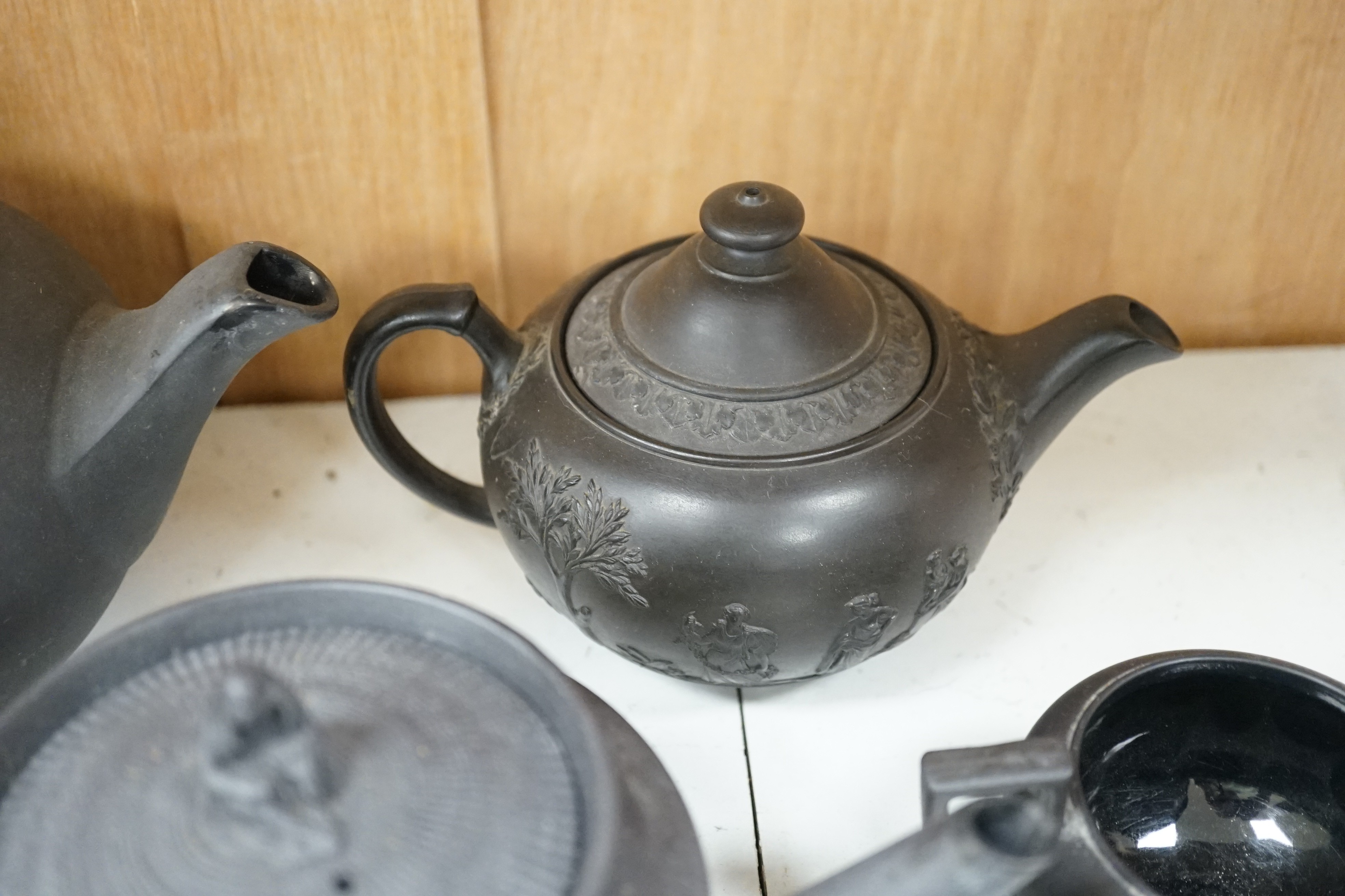 A collection of Wedgwood and other black basalt teapots and tea wares, 19th/early 20th century, tallest teapot 17cms high